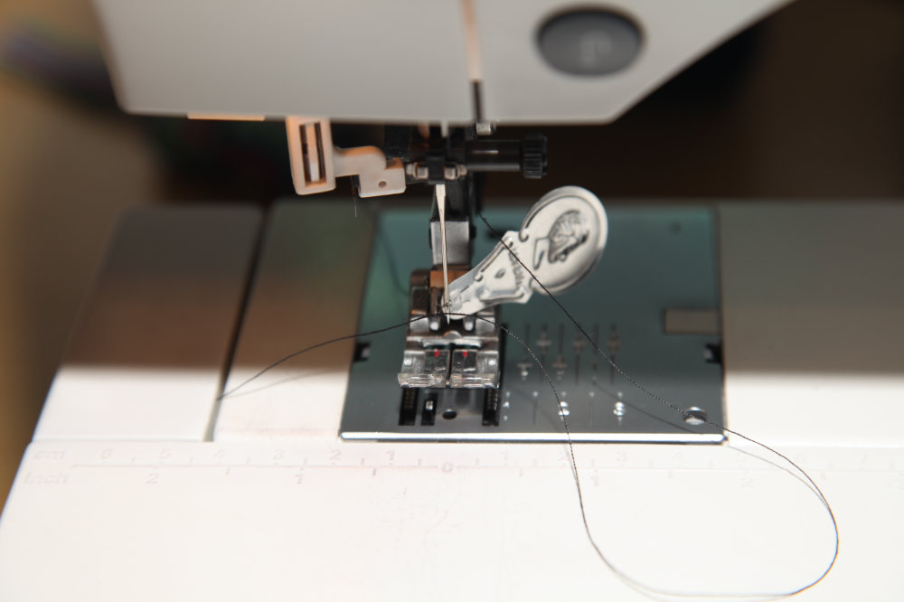 Needle threader being used to thread the needle on a sewing machine